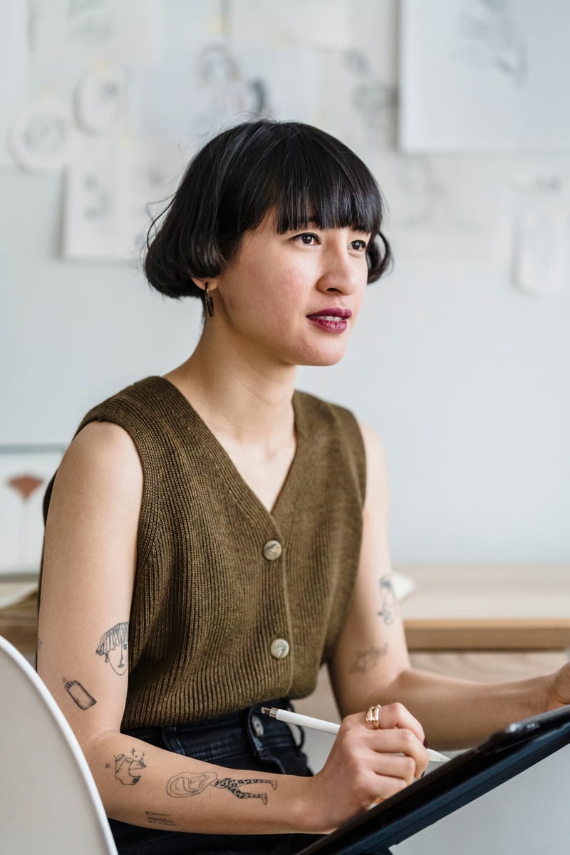 Attentive Asian female designer with tablet at work